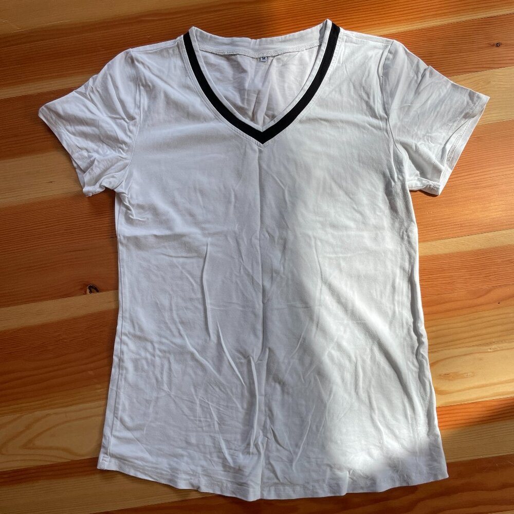 Plain white T with blue trim around the neck.